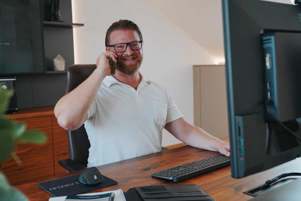 Mann beim Telefonieren an seinem Arbeitsplatz